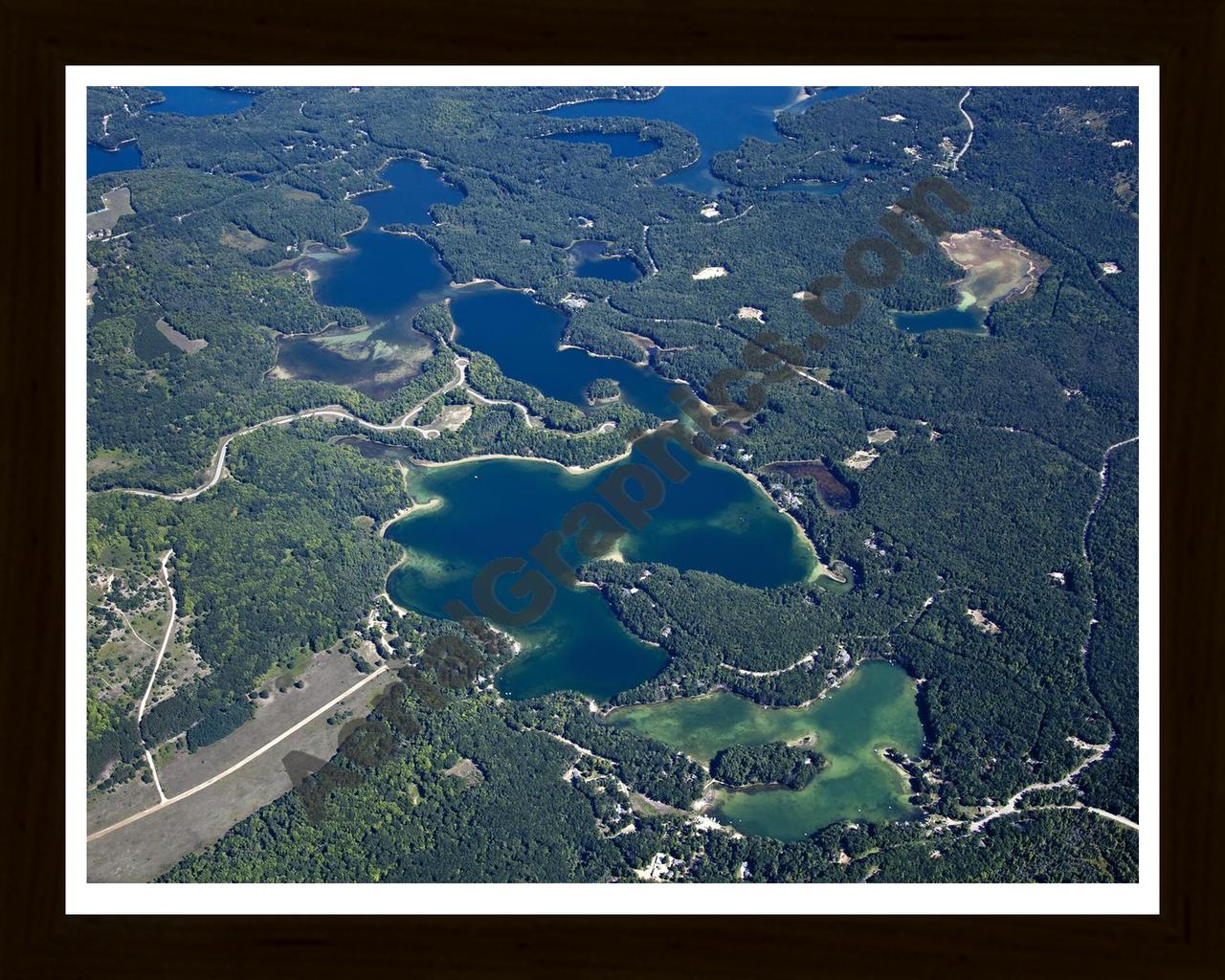 Aerial image of [5604] Arbutus Lake in Grand Traverse, MI with Black Wood frame